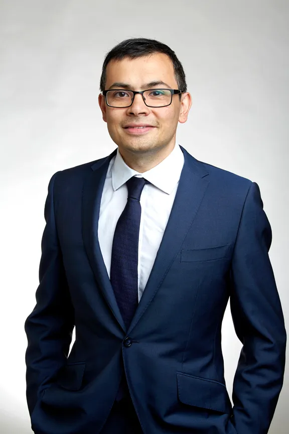 Demis Hassabis photographed at the Royal Society in 2018, in a dark jacket, looking towards the camera.