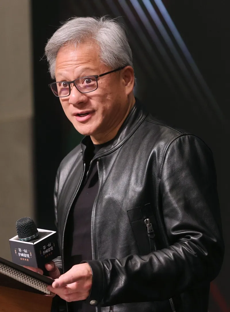 Jensen Huang, Nvidia founder and CEO, in his trademark black leather jacket, speaking at an awards ceremony.